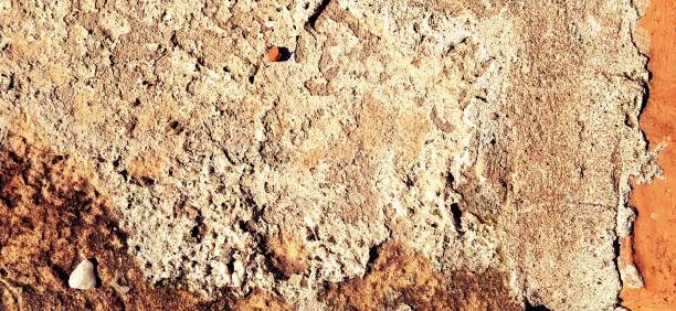istock Brick or stone close-up. Texture or background. Bright red, brown, orange, beige colors. Dust, small pebbles, sand, soil and moss on uneven surfaces. Environmental impact. Natural daylight or sunshine 1266495775