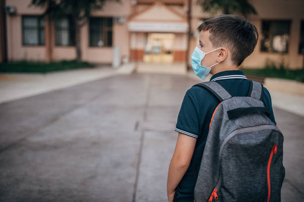 istock Schoolboy with protective face mask going to school 1266505076