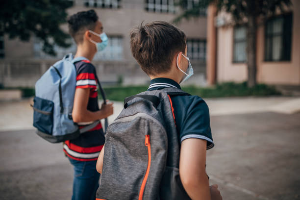 istock Caucasian schoolboys with protective face masks going to school 1266505902