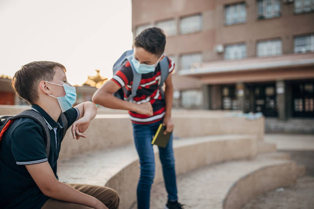 istock Two schoolboys with surgical masks outside their elementary school building 1266507323