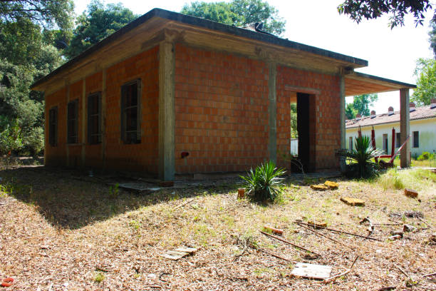 istock Construction work in an incomplete red brick and concrete house with architectural style details in countryside 1266507520