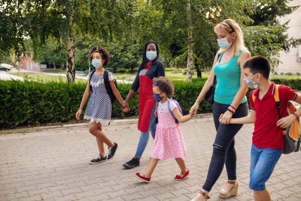 istock Parents with elementary school students going to school with face masks 1266512167
