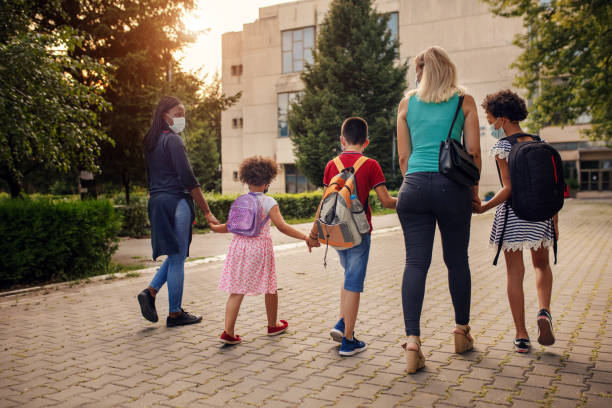 istock Parents with elementary school students going to school with face masks 1266512190