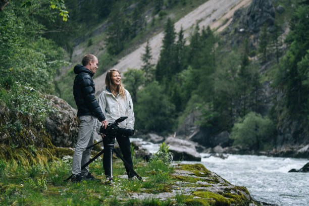 istock A couple organize a large camera on a tripod on a rainy day 1266514169