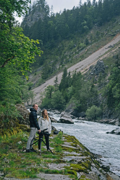 istock A couple organize a large camera on a tripod on a rainy day 1266514243