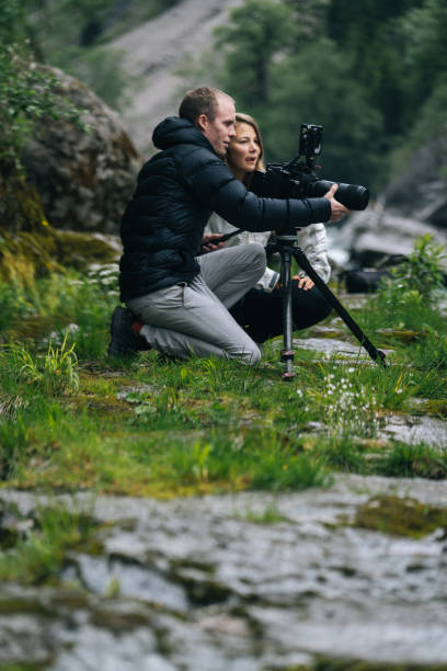 istock A couple organize a large camera on a tripod on a rainy day 1266514304
