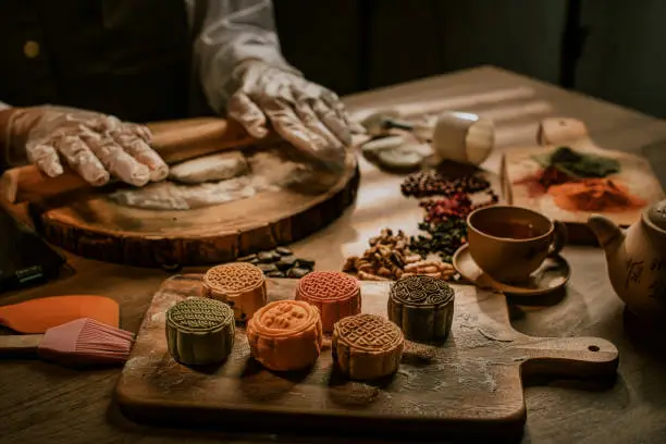 an asian chinese beautiful woman making chinese traditional mid-autumn snow skin mooncake at her kitchen