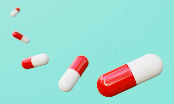 istock Red and white capsules on cyan green background. 1266526399