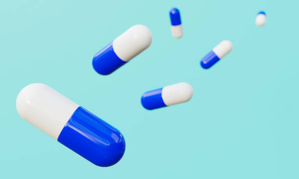 istock Red and white capsules on cyan green background. 1266526400