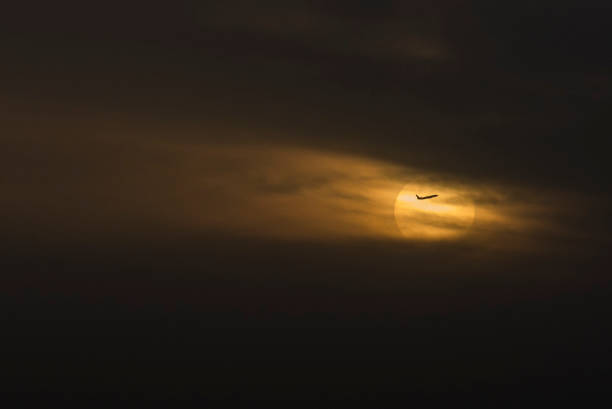istock Airplane crosses the sun 1266543565