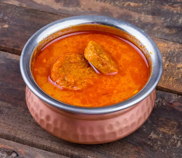 Photo of Indian Traditional Cuisine Gatta Curry on Wooden Background