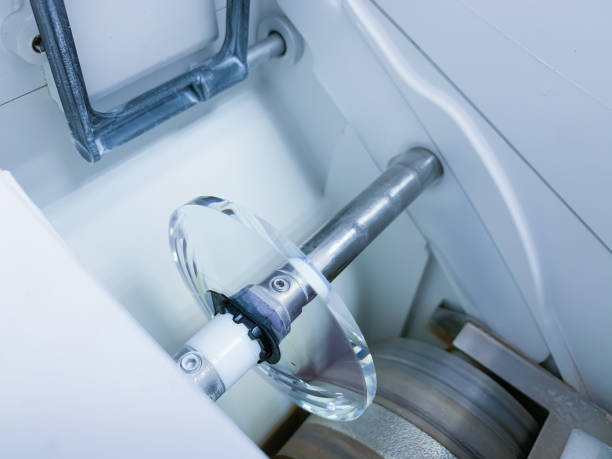 istock transparent optical lens in the processing chamber of the automatic milling machine. 1266543643