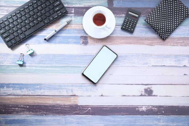 istock smart phone with empty screen and office stationary on table 1266547306