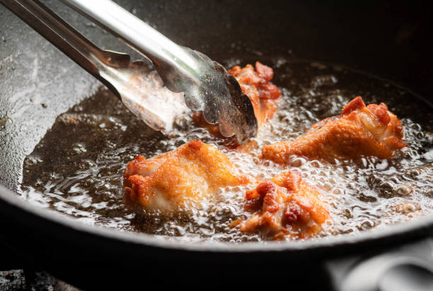 coxas de frango fritas em óleo fervente. comida de rua tailandesa. - chicken pot - fotografias e filmes do acervo