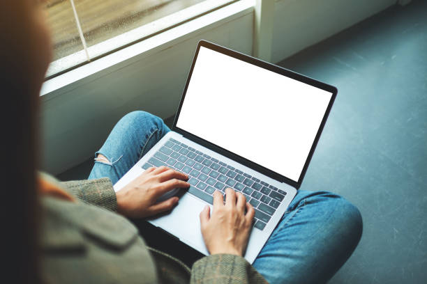 istock a woman working and typing on laptop computer with blank screen while sitting on the floor 1266550025