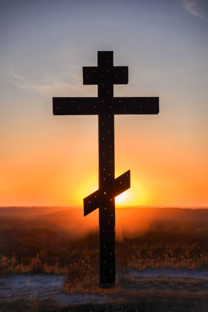 istock Silhouette of cross on mountain sunset background 1266550105