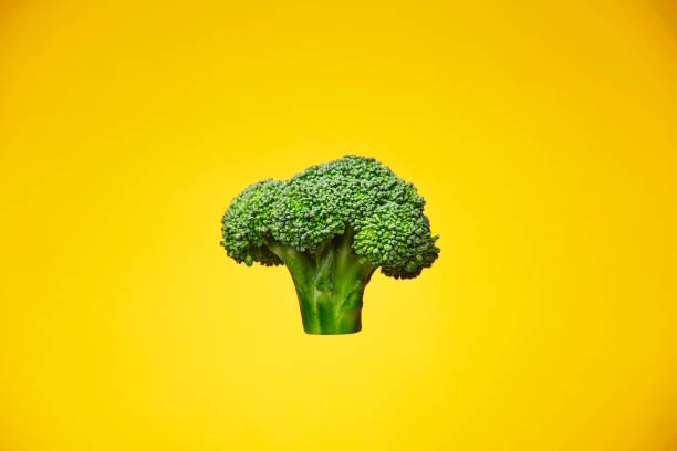 istock Green fresh broccoli on the yellow background 1266551795
