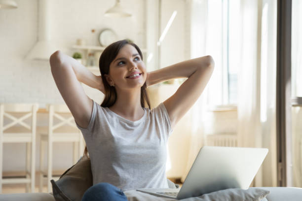 istock Calm dreamful young woman working on computer at home 1266551905