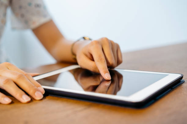 istock Young Asian woman using digital tablet on top of table 1266553770