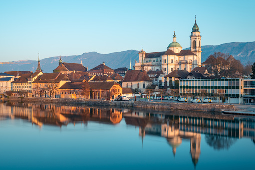 the cathedral is reflected in the aare river. In the background of the city is the local mountain Weissenstein. Canton Solothurn, Switzerland, Euorpe
