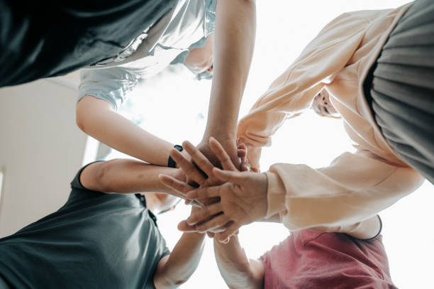 istock friends holding hand from angle below for hope and trust 1266555627