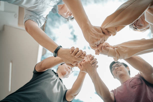 istock friends holding hand from angle below for hope and trust 1266555628