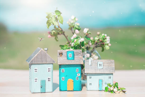 Toy wooden houses with a blooming bouquet of Apple trees in nature on a Sunny day. stock photo