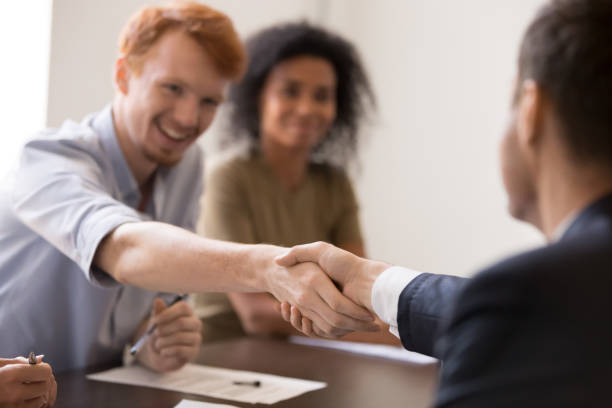 istock Happy employees shaking hands at briefing, sharing success 1266558167