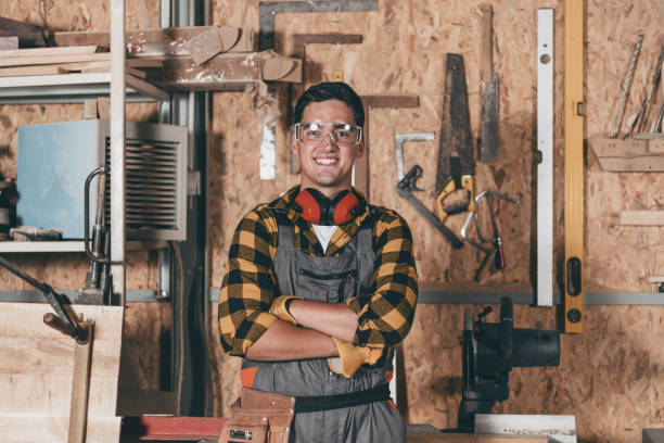 workshop is my world. happy young male carpenter keeping arms crossed - real world imagens e fotografias de stock