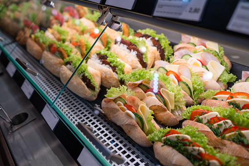 many fresh filled sandwiches in display case of railway station takeaway