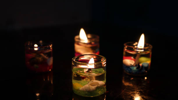 istock Colorful candles and golden flame reflection on dark surface 1266562315
