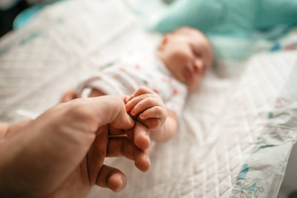 istock Hand holding newborn baby's hand 1266566685