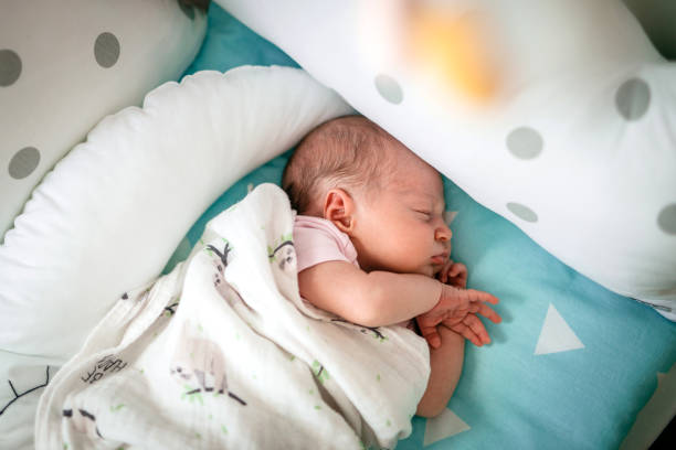 neonato che dorme nel suo presepe - baby sleeping bedding teddy bear foto e immagini stock