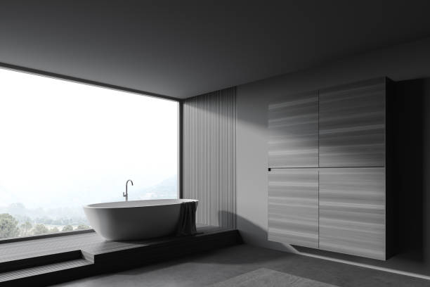 istock Grey and wooden bathroom with tub and wardrobe 1266567103