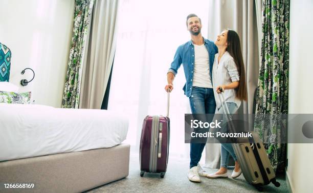 Young Beautiful Happy Excited Couple In Love With Suitcases In A Modern Hotel During Vacation Stock Photo - Download Image Now