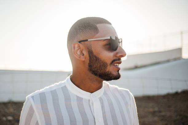 Portrait of a confident and casual man, modern muslim wearing sunglasses Portrait of a confident and casual man, modern muslim wearing sunglasses, natural outdoor light. arabian sunglasses stock pictures, royalty-free photos & images