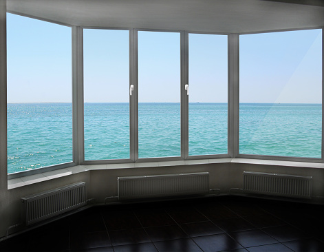 Cozy room overlooking the sea. Landscape with ocean. modern plastic window with view of horizon with marine surface. Travel concept. Glass in window. Window with beautiful panorama