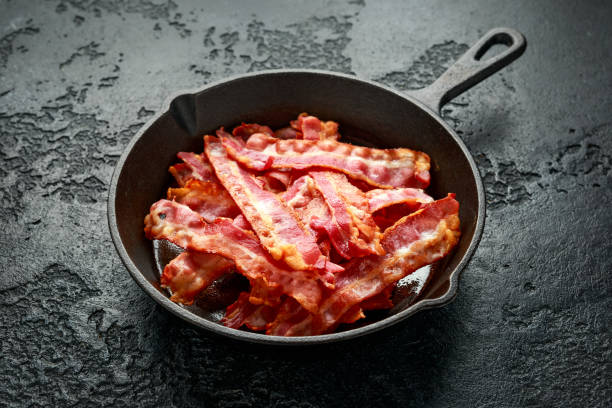istock Fried crunchy Streaky Bacon pieces in a cast iron skillet 1266579348