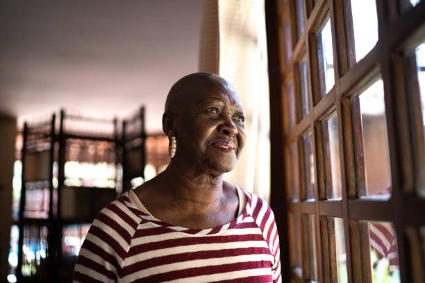 istock Senior woman contemplating, looking through the window 1266580718