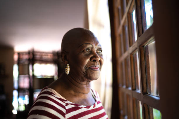 istock Senior woman contemplating, looking through the window 1266580912