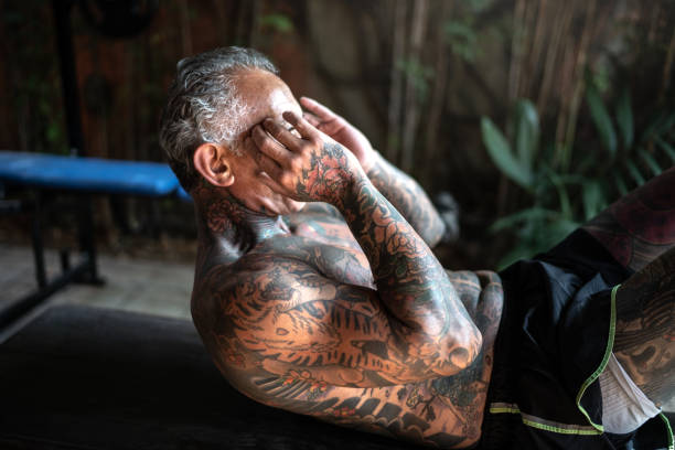 istock Mature man doing sit-ups at home 1266581845