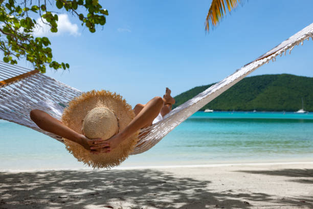 istock Woman relaxing in a hammock on a tropical beach 1266584255