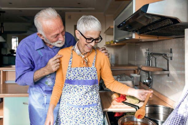 istock Happy Older Man and his Wife are Spending a Nice Time While Enjoying in Dinner Preparation at Home. 1266584361