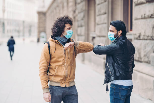 istock Two young men greet with elbow bump on the street 1266587424