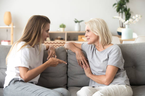 istock Two female sitting on couch and talking 1266588191