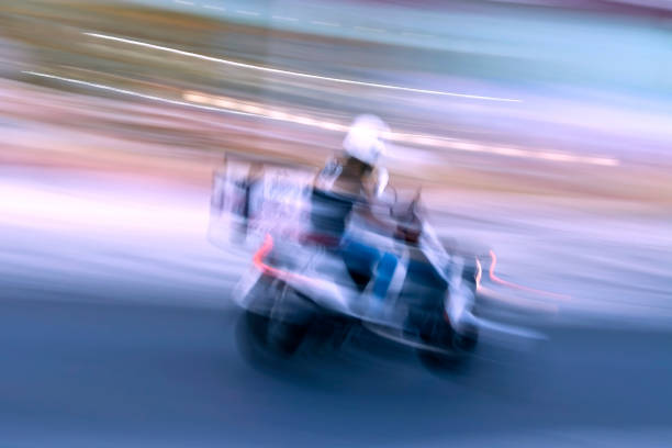 istock Delivery boy on motorbike in motion 1266589679