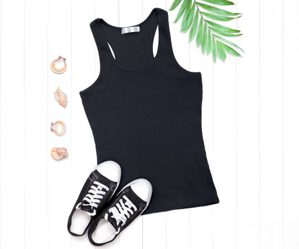 istock Black tank top with sneakers and seashells on a white background 1266589899