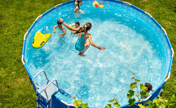 Kids enjoying splashing in swimming pool Kids enjoying jumping and splashing in swimming pool staycation stock pictures, royalty-free photos & images