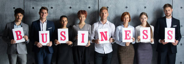 istock People holding BUSINESS letters 1266590867