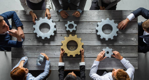 istock Business people joining gears 1266590900